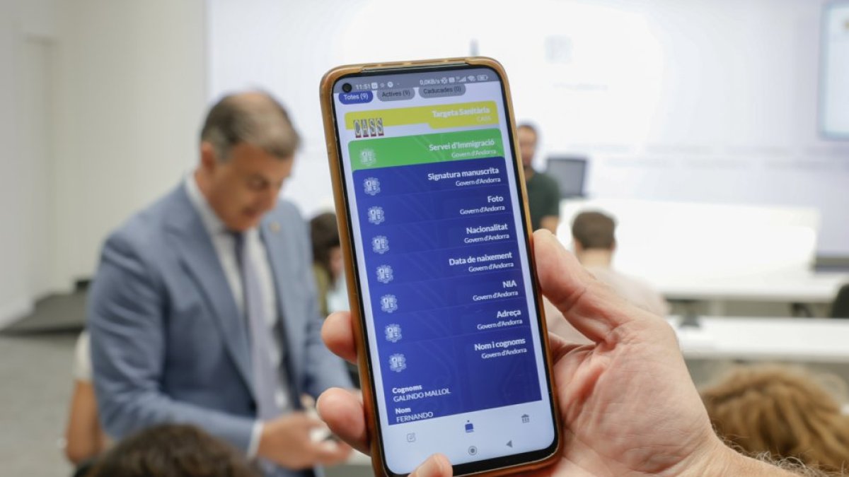 El ministre Rossell, al fons, fent servir la cartera digital.