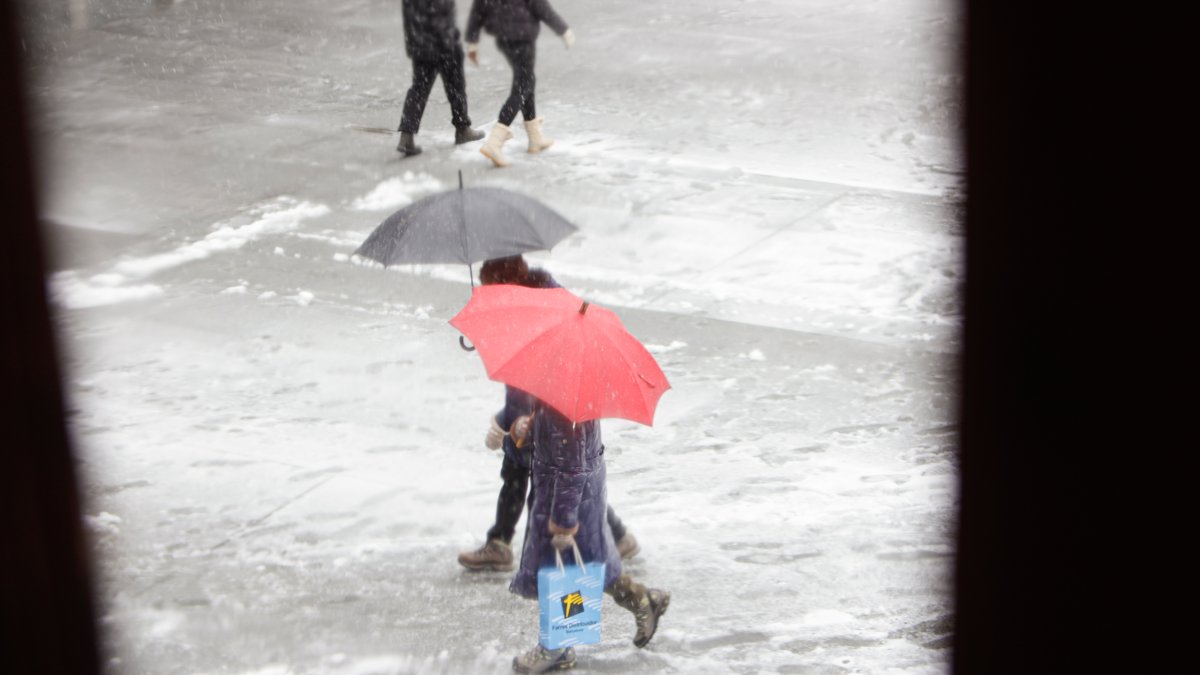 Dues persones caminant sota la neu.