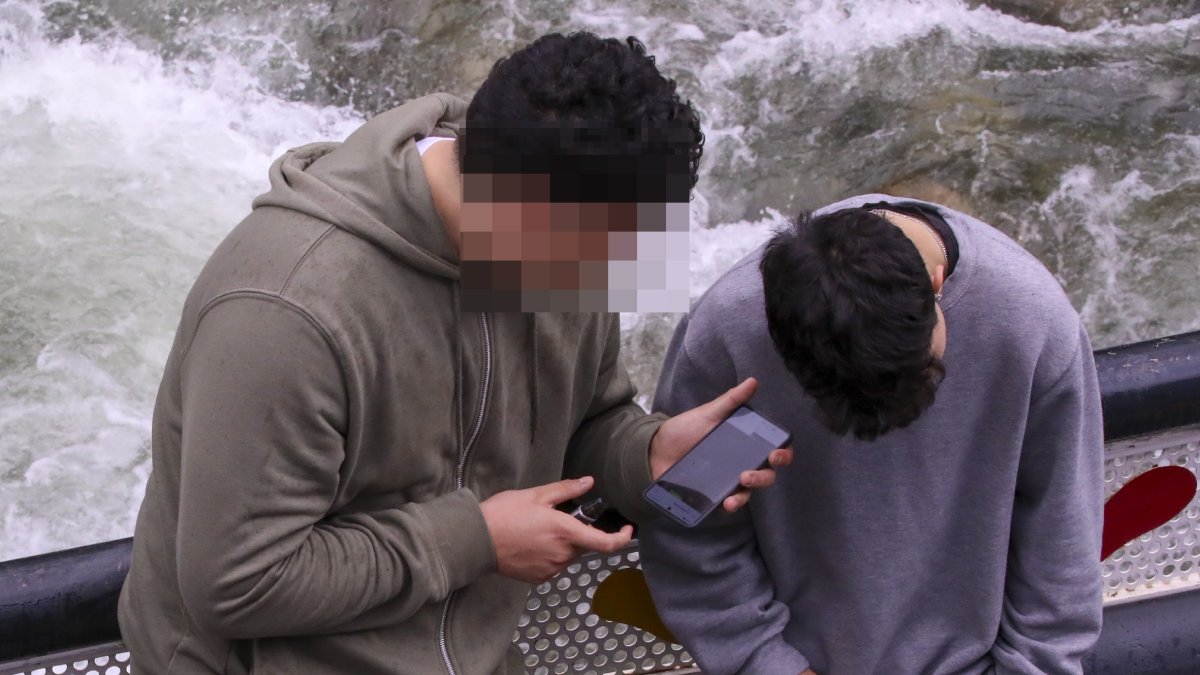 Dos joves amb un dispositiu mòbil.