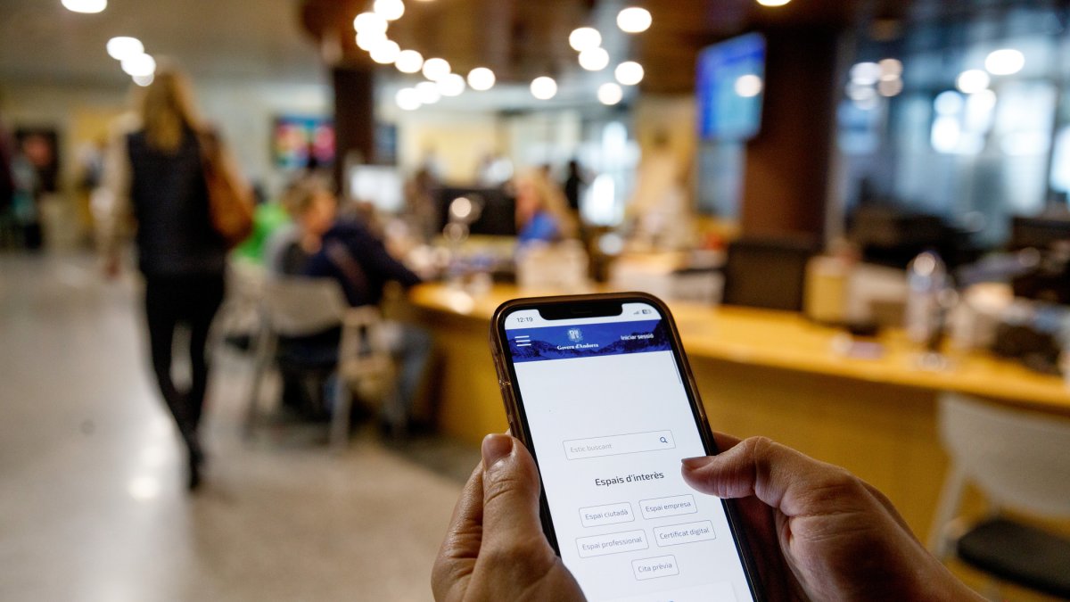 Una persona utilitzant un telèfon intel·ligent a l’edifici del Govern.