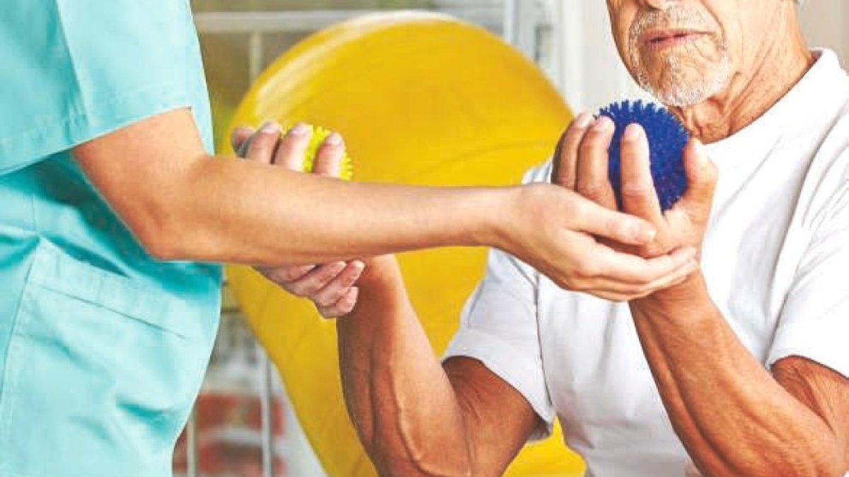 Un pacient sent atès per un fisioterapeuta.