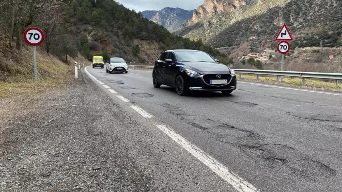 Vehicles circulant per un tram de la carretera N-260 ple de clots.