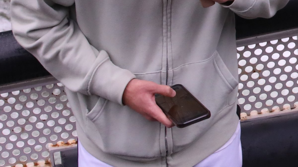 Un adolescent mirant el mòbil.