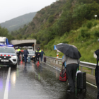 Viatgers d'Andbus sota la pluja per passar el bloqueig