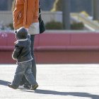 Un nen, de la mà de la seva progenitora.