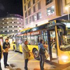 Dos passatgers esperant per pujar a l’autobús, ahir a la tarda.