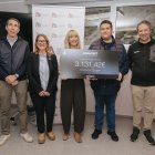 Directius de l'Abarset amb un cartell on s'indica la quantitat recaptada.