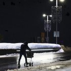 Un treballador del Pas traslladant material sota una intensa pluja.