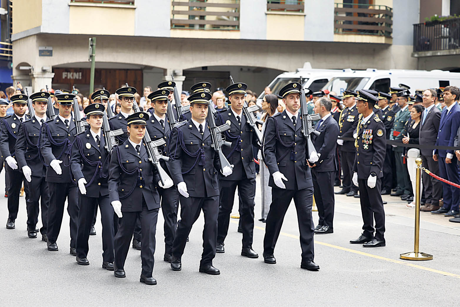A group of police officers parading in front of the authorities on patron saint's day.