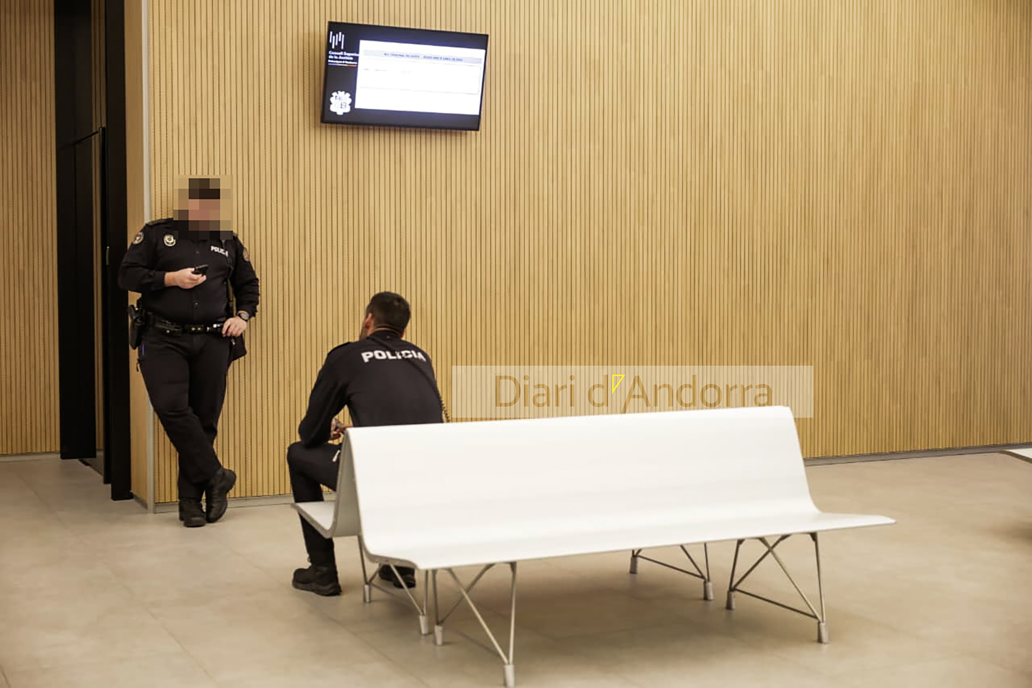 Two police officers at the door of the room where the trial is held.